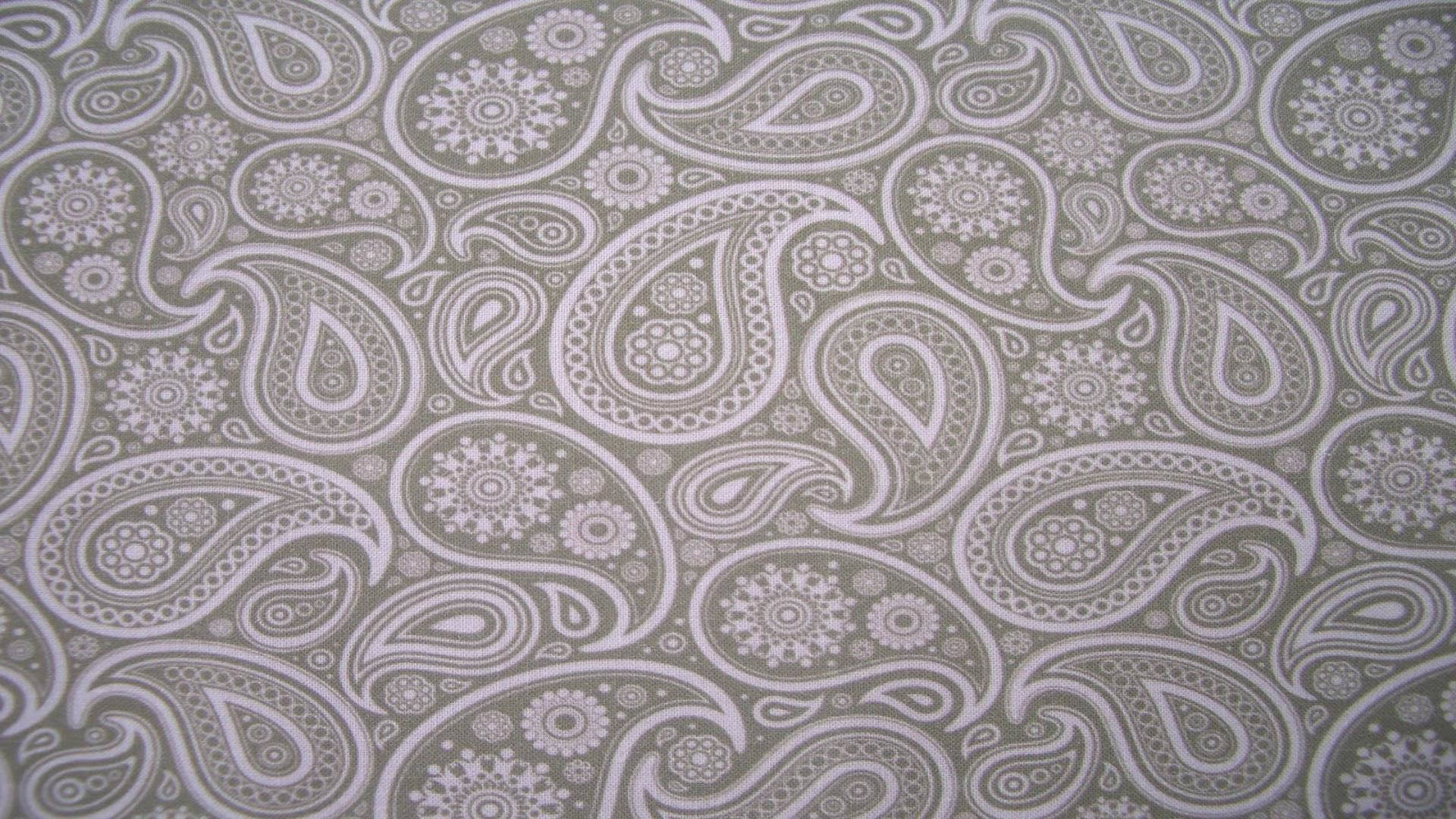Paisley 桌布 壁紙 — 灰色布料的特寫，表面重複著複雜的白色佩斯利和花卉圖案。