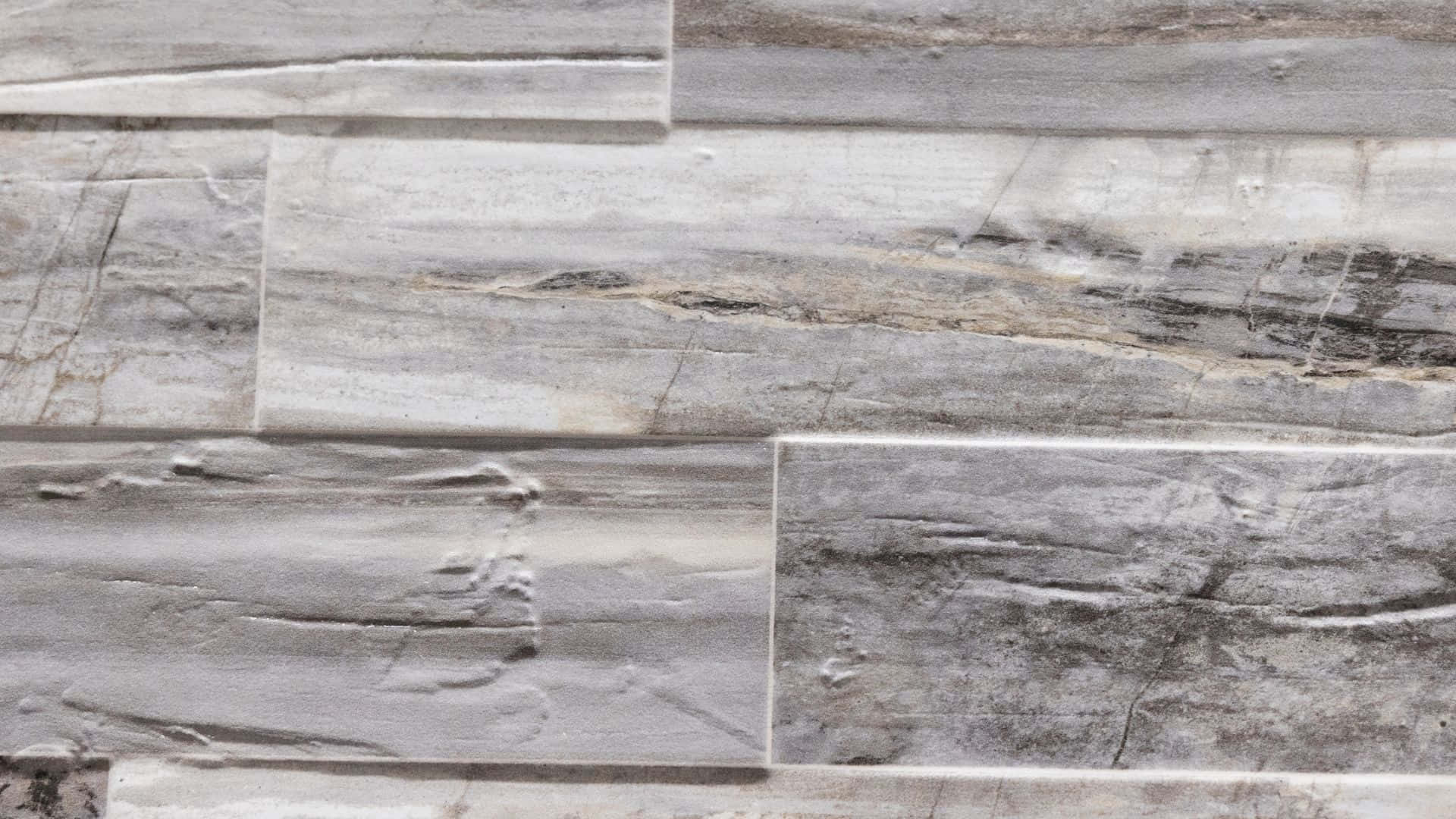 Tile 桌布 壁紙 — 灰色石磚的特寫，具有天然紋理和分層質感，以交錯的水平行排列。