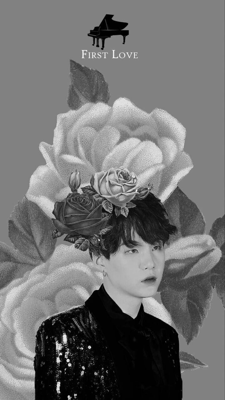 Suga Bts 桌布 壁紙 — 灰色背景上，一位年輕男子頭頂有玫瑰和三角鋼琴圖示的黑白肖像。