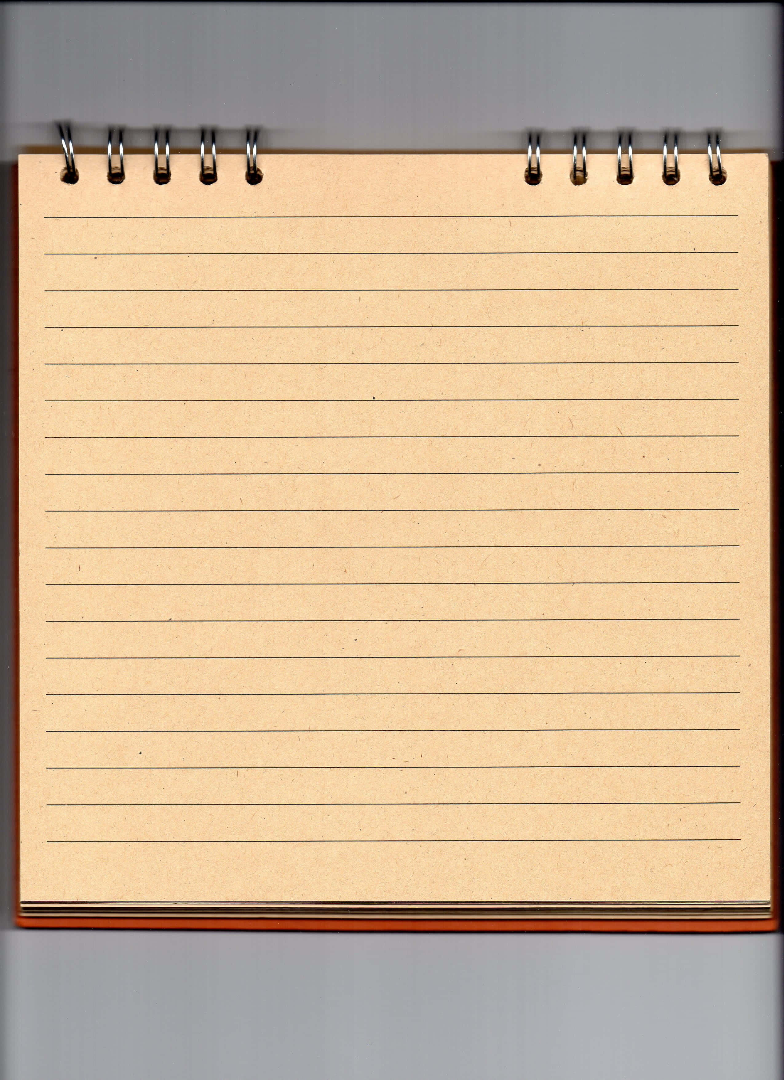 notes 桌布 壁紙 — 灰色背景上，一本打開的螺旋裝訂筆記本的近照，帶有米色橫線紙和棕色封面。