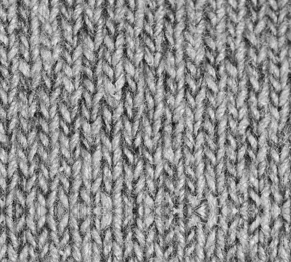 clothing 桌布 壁紙 — 灰色針織布料的特寫，顯示細緻的針跡圖案和柔軟纖維。