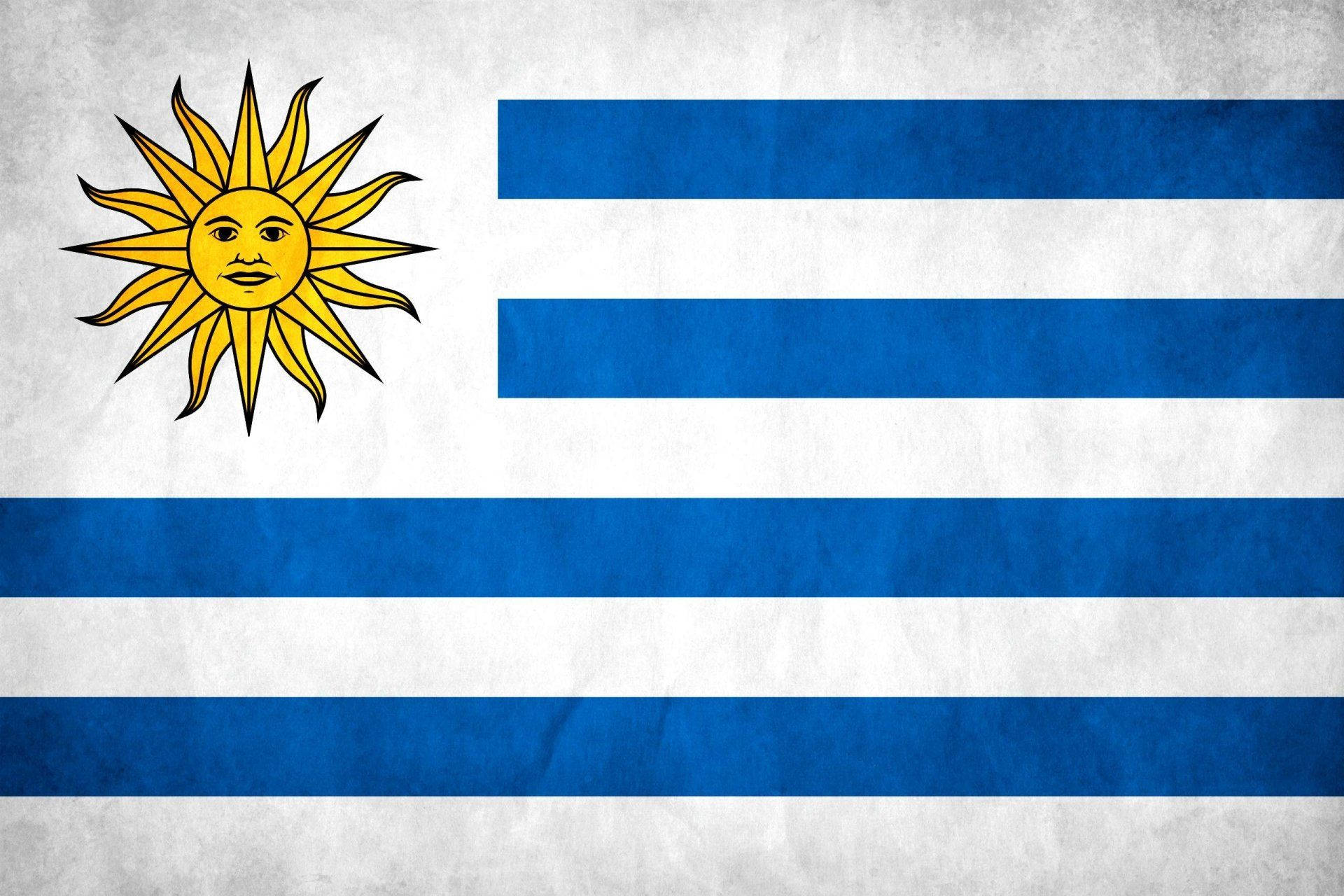 Uruguay 桌布 壁紙 — 烏拉圭國旗，帶有藍白條紋和黃色太陽標誌，布料有紋理。