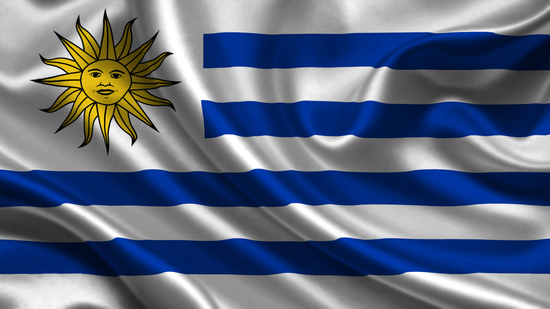 Uruguay 桌布 壁紙 — 烏拉圭國旗動態飄揚，帶有鮮明的藍白條紋和燦爛的金色太陽標誌。