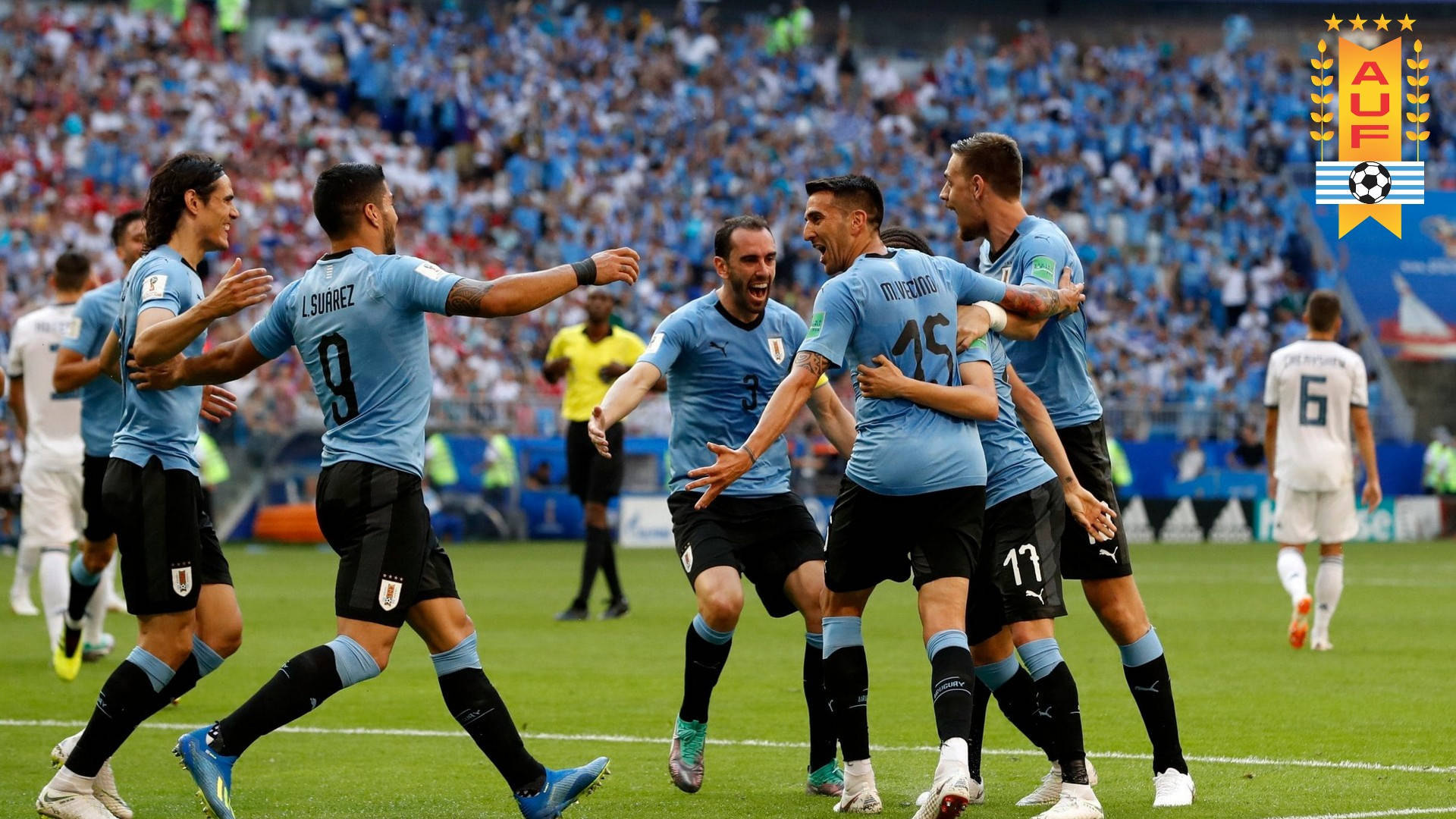 Uruguay 桌布 壁紙 — 烏拉圭足球員身穿淺藍色球衣，在陽光明媚的球場上以強烈的喜悅慶祝進球。