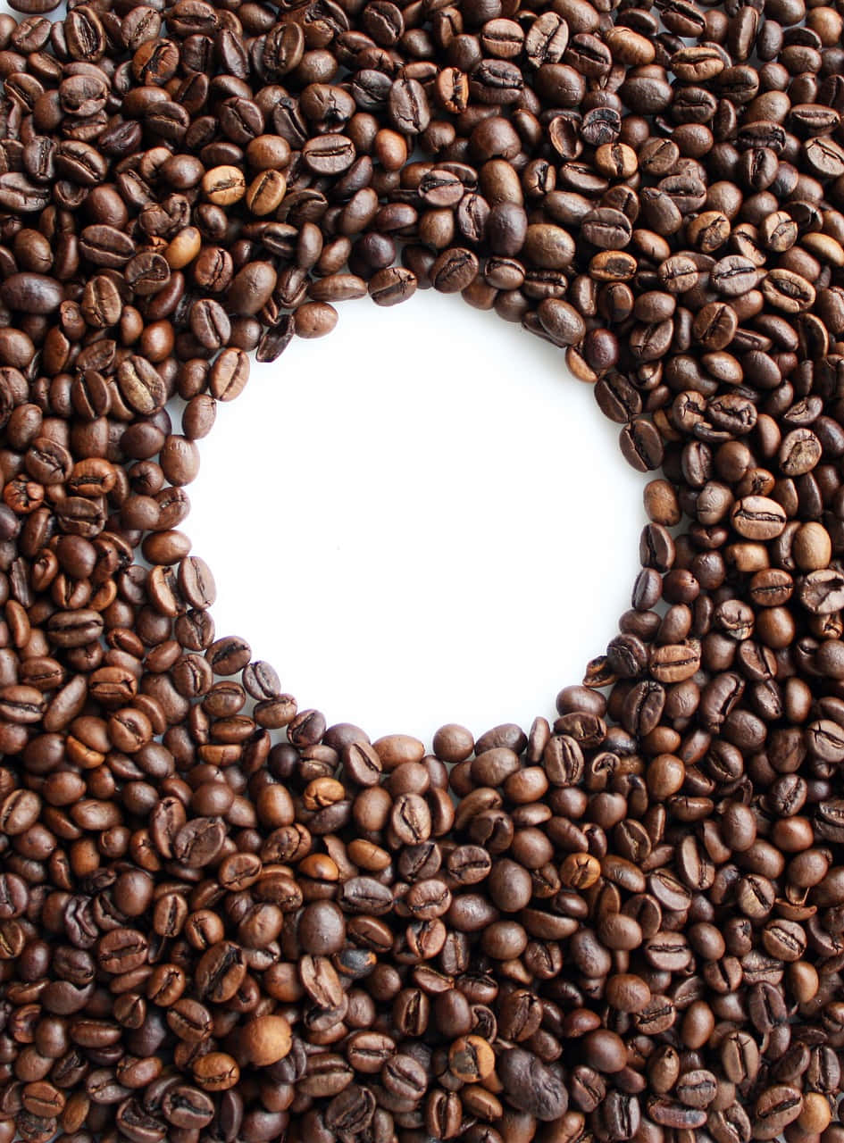 Coffee Beans 桌布 壁紙 — 烘焙咖啡豆排列成圓形框架，圍繞著空白的白色中心。