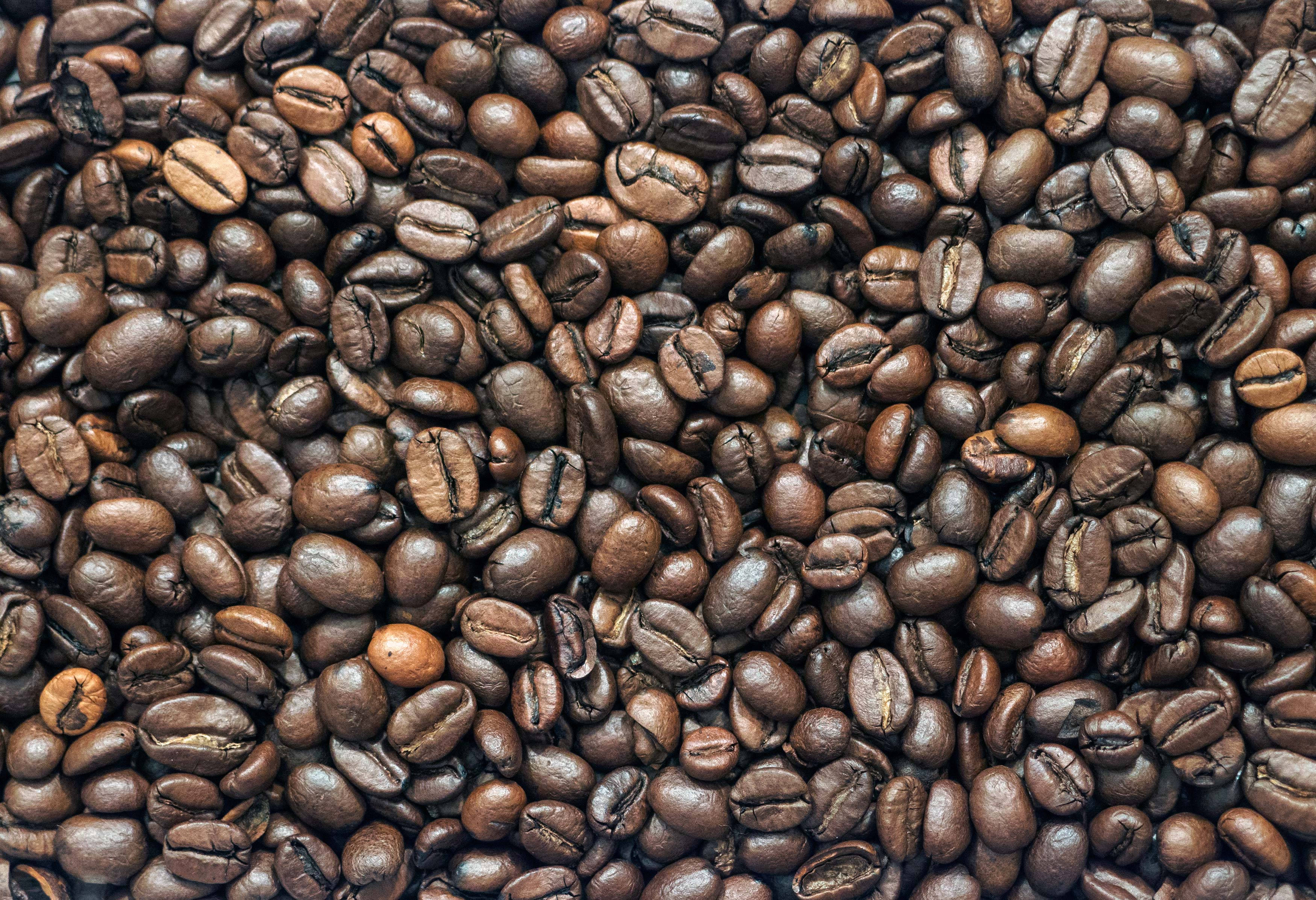 beans 桌布 壁紙 — 烘焙咖啡豆的特寫，帶有豐富的棕色色調和可見的皺紋。