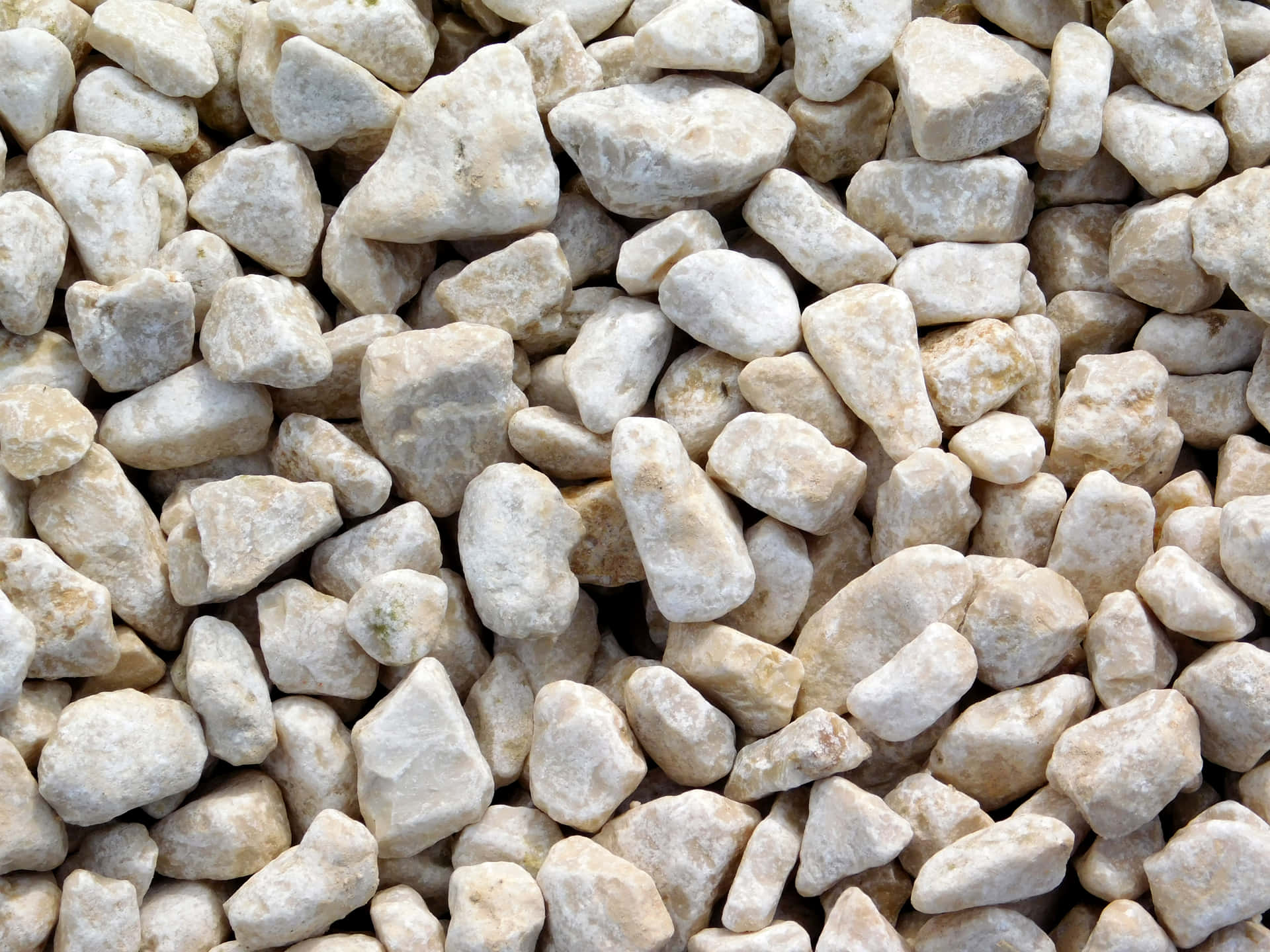 Stone texture 壁紙 — 無數光滑圓潤的石頭以奶油色米色和灰白色調緊密堆疊在一起的近距離特寫。