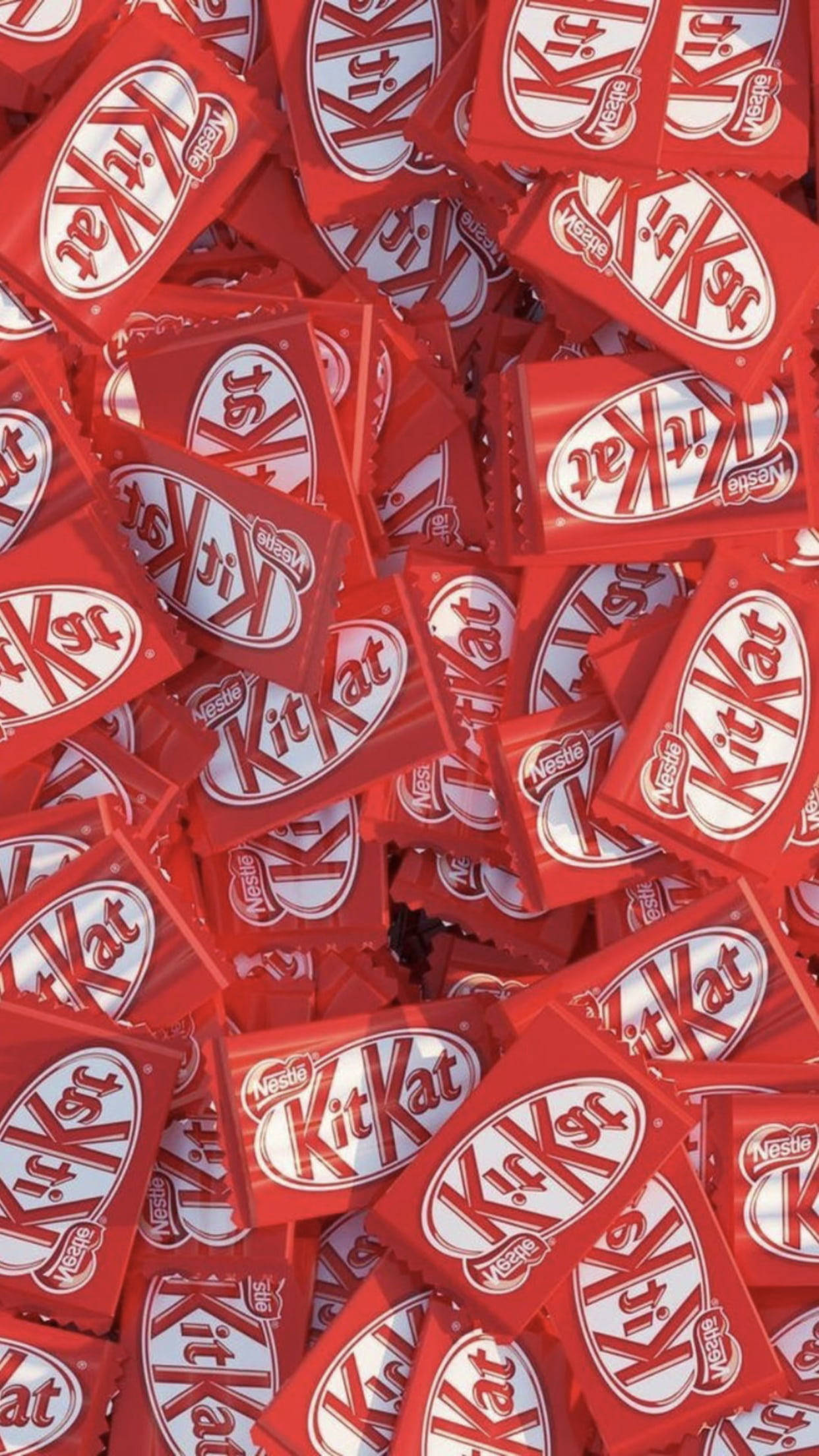 Chocolate 桌布 壁紙 — 無數紅色KitKat巧克力棒堆疊在一起，形成一個混亂而甜蜜誘人的特寫。