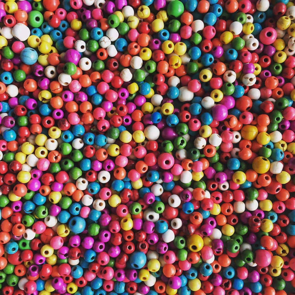 Bead 桌布 壁紙 — 無數色彩繽紛的木珠以彩虹色調緊密排列的鮮明特寫。