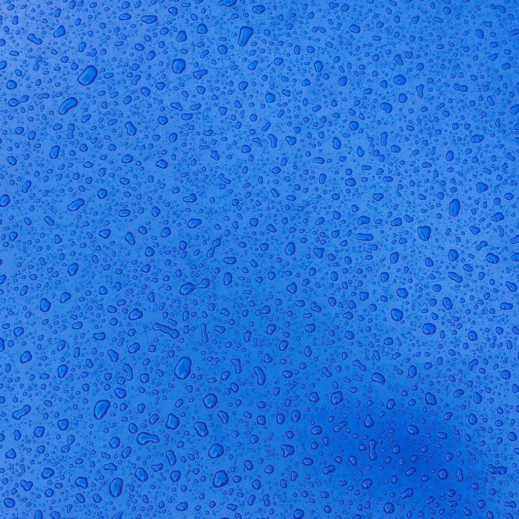 Rain Drops 桌布 壁紙 — 無數閃亮的水珠散落在光滑的藍色表面上，形成清涼清爽的質感。