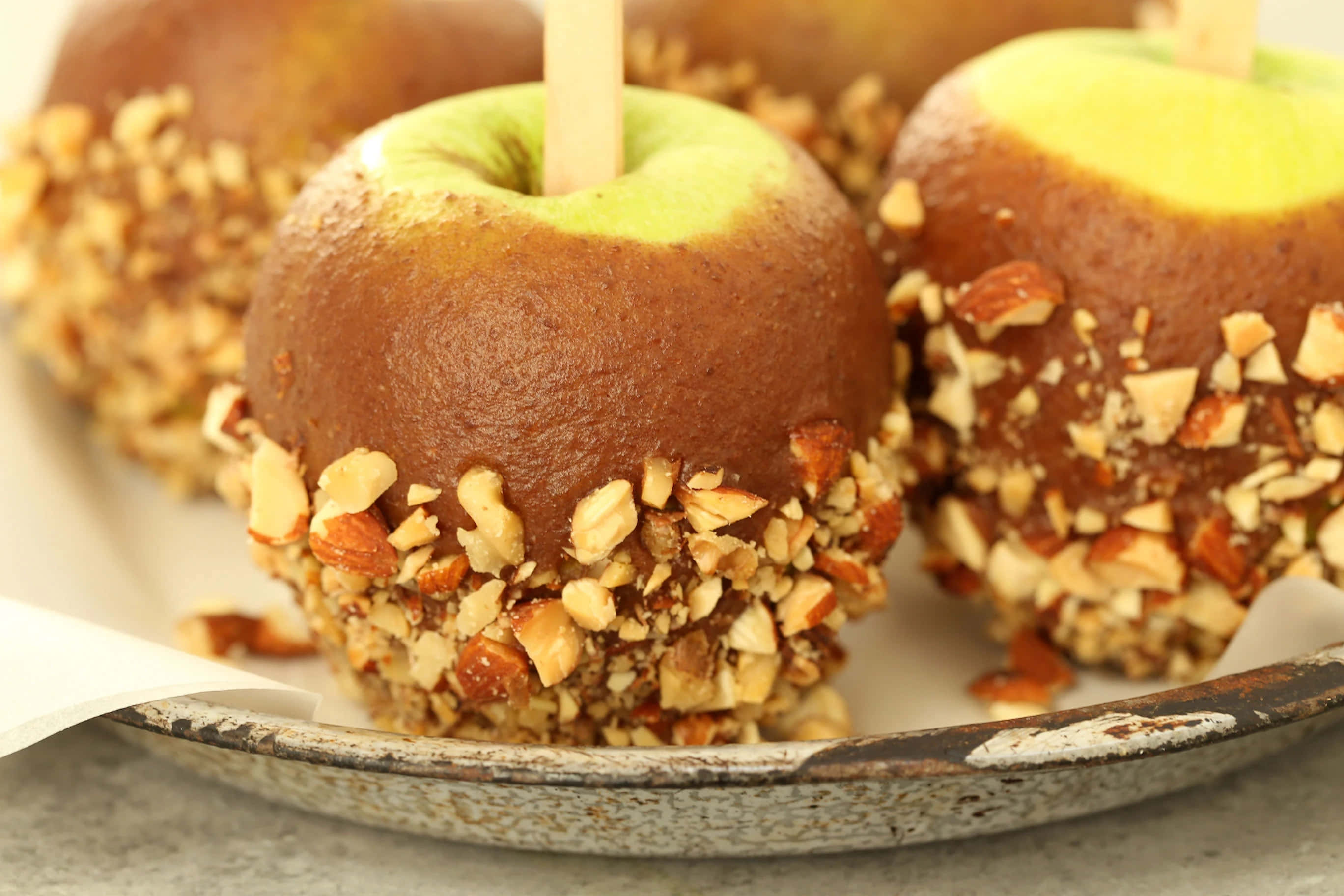 Caramel Apples 桌布 壁紙 — 焦糖蘋果裹上碎堅果，放在質樸的陶瓷盤上。