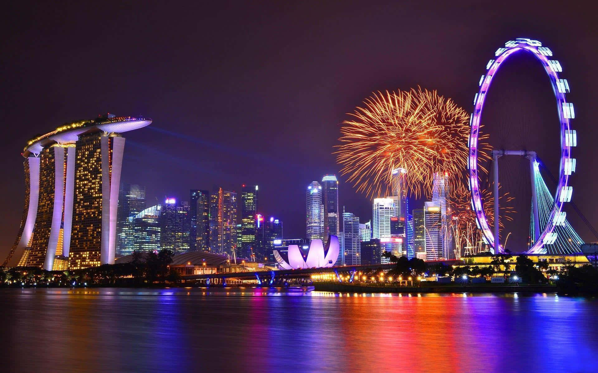 Singapore 桌布 壁紙 — 煙火在新加坡閃爍的天際線上綻放，濱海灣金沙和新加坡摩天輪在夜晚被照亮。