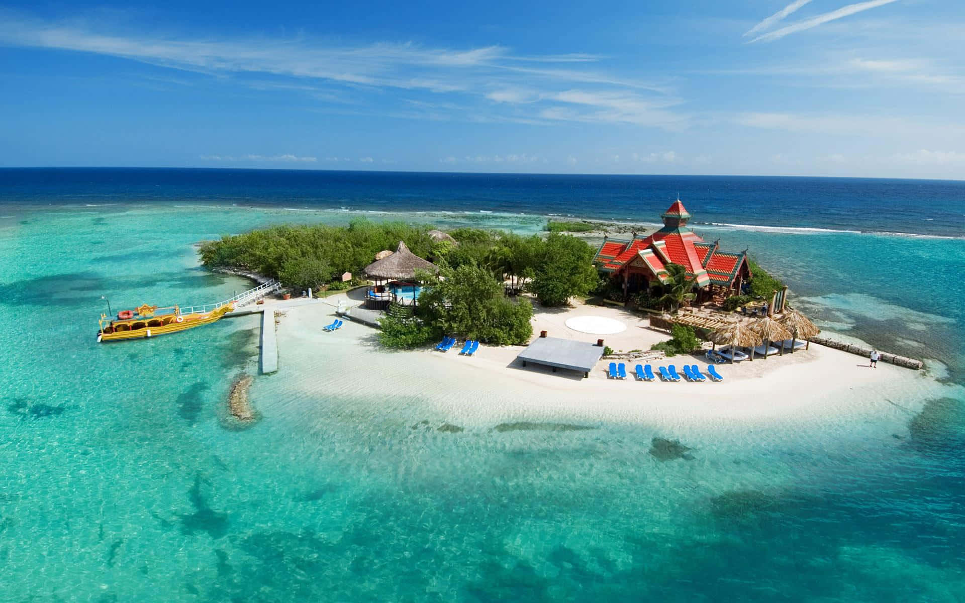 Jamaica 桌布 壁紙 — 熱帶島嶼度假村的鳥瞰圖，擁有碧綠的海水、白色沙灘和紅頂建築，在晴朗的藍天下。