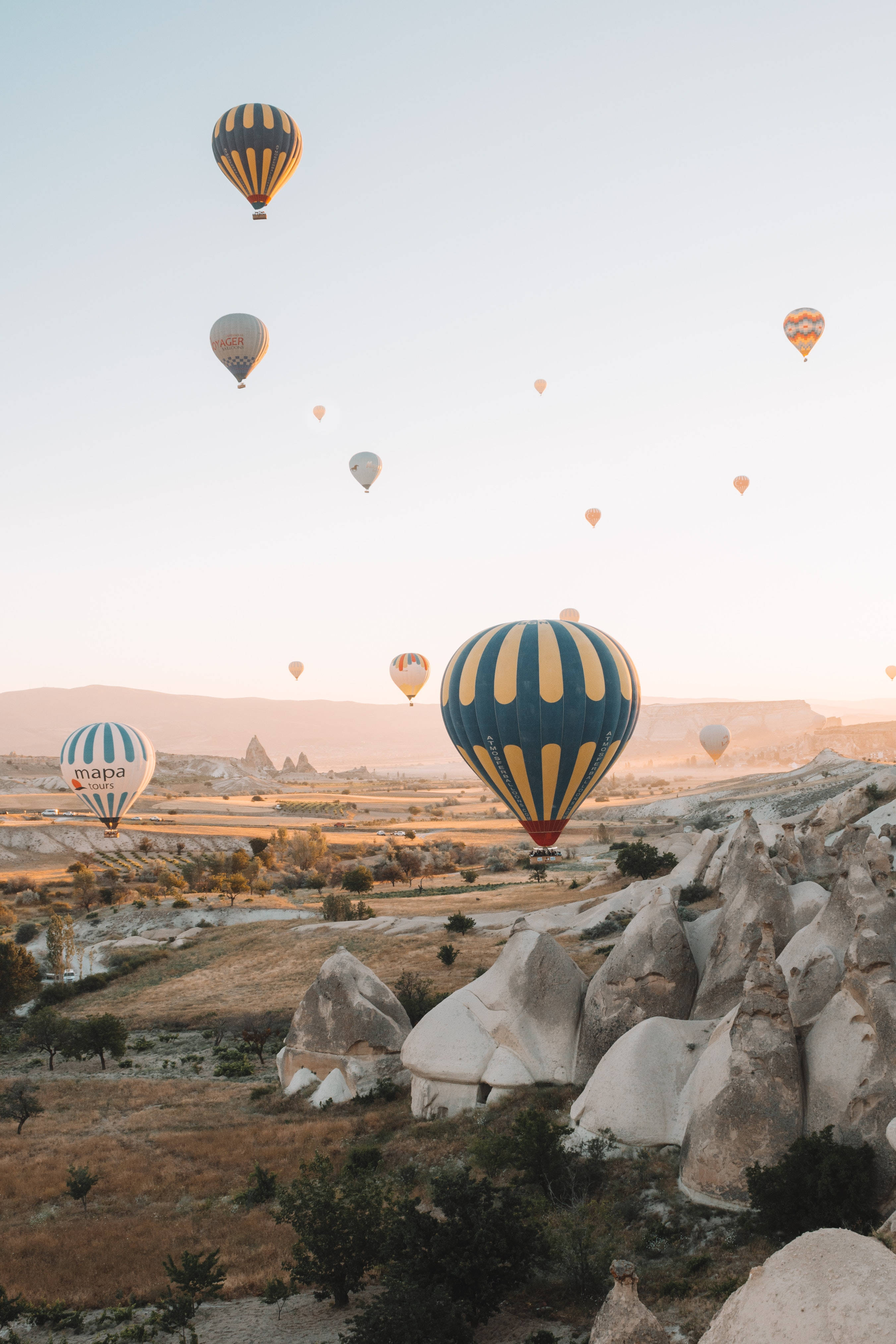 Hot Air Balloon 桌布 壁紙 — 熱氣球在金色日出時飄過卡帕多奇亞超現實的岩石地貌。