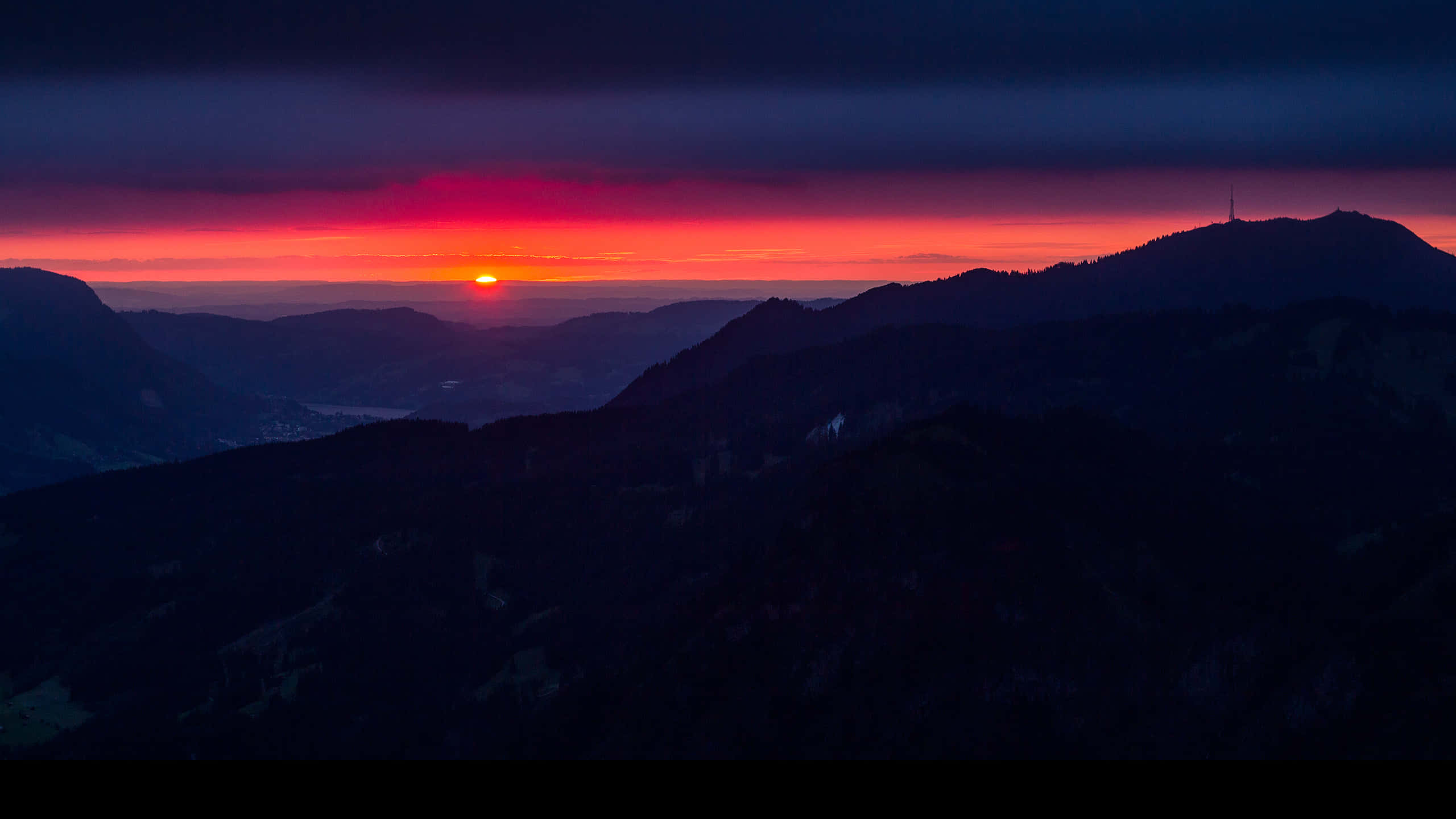 山脈 桌布 壁紙 — 熾熱的夕陽在黑暗的山巒剪影上，將天空染成鮮豔的紅色和紫色。