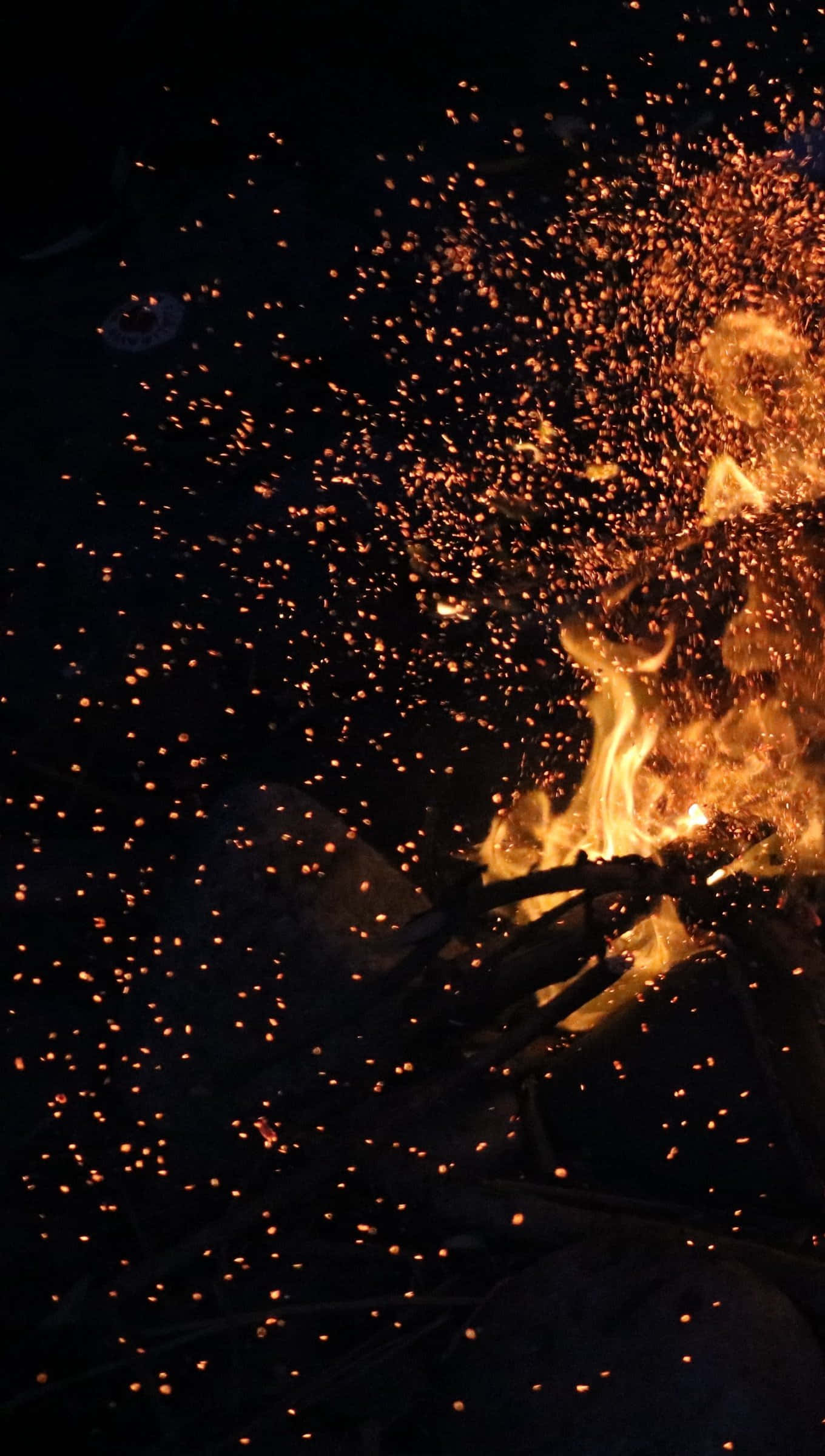 Fall Bonfire 桌布 壁紙 — 熾熱的火花從咆哮的營火中迸發，映襯著漆黑的夜空。