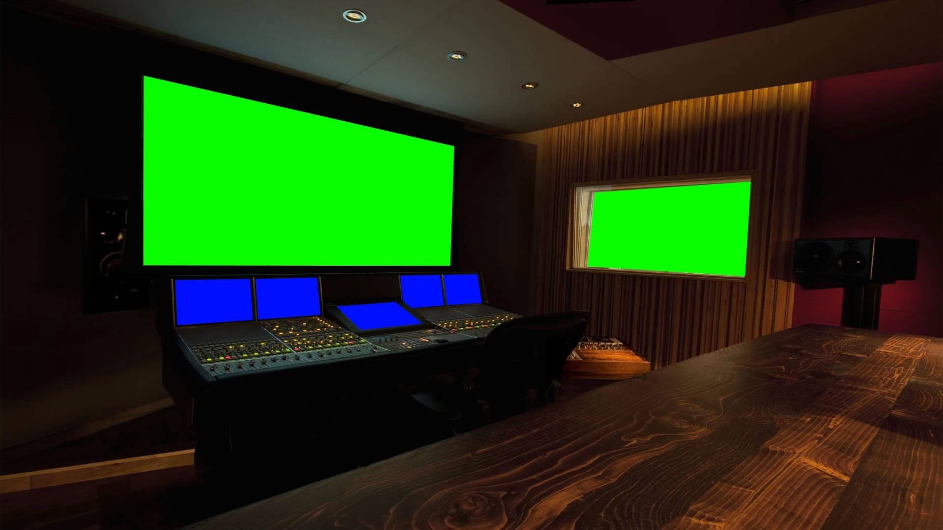 Green Screen 桌布 壁紙 — 燈光昏暗的專業影片工作室，帶有發光的綠色螢幕和木地板。