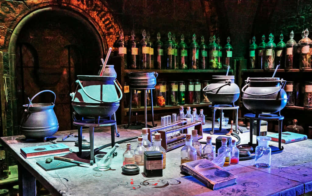 The Hogwarts Potions Class 桌布 壁紙 — 燈光昏暗的煉金術實驗室，銅鍋在火焰上冒泡，架子上擺滿了發光的綠色玻璃瓶。