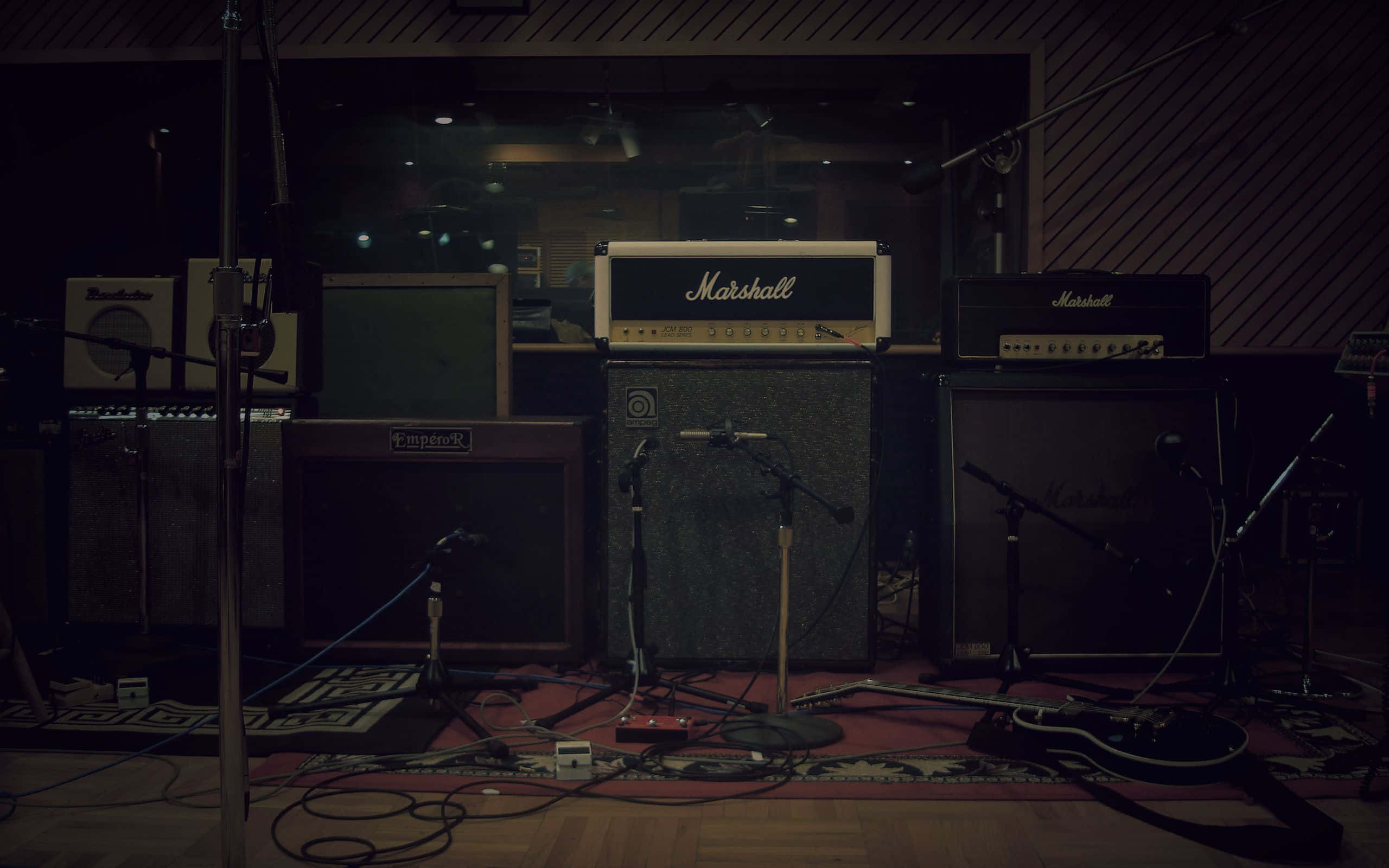 Marshall 桌布 壁紙 — 燈光昏暗的錄音室，配備復古 Marshall 擴音器和麥克風，為搖滾樂團表演而佈置。