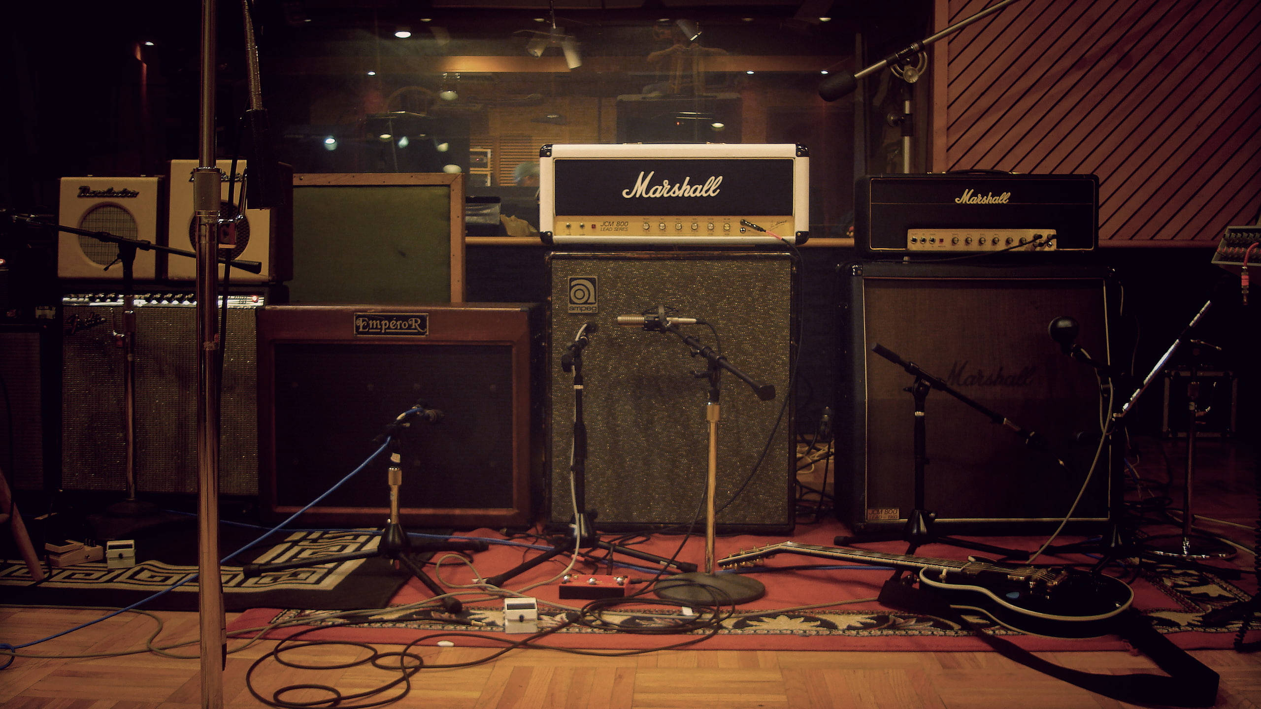 Marshall 桌布 壁紙 — 燈光昏暗的音樂工作室，充滿了復古吉他擴音器和支架上的麥克風。