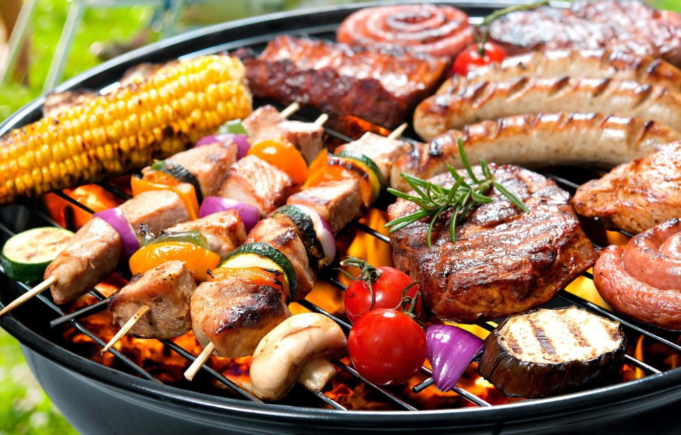 Bbq 桌布 壁紙 — 燒烤架上滋滋作響，滿載色彩繽紛的串燒蔬菜、香腸和牛排，在明亮的橙色火焰上。