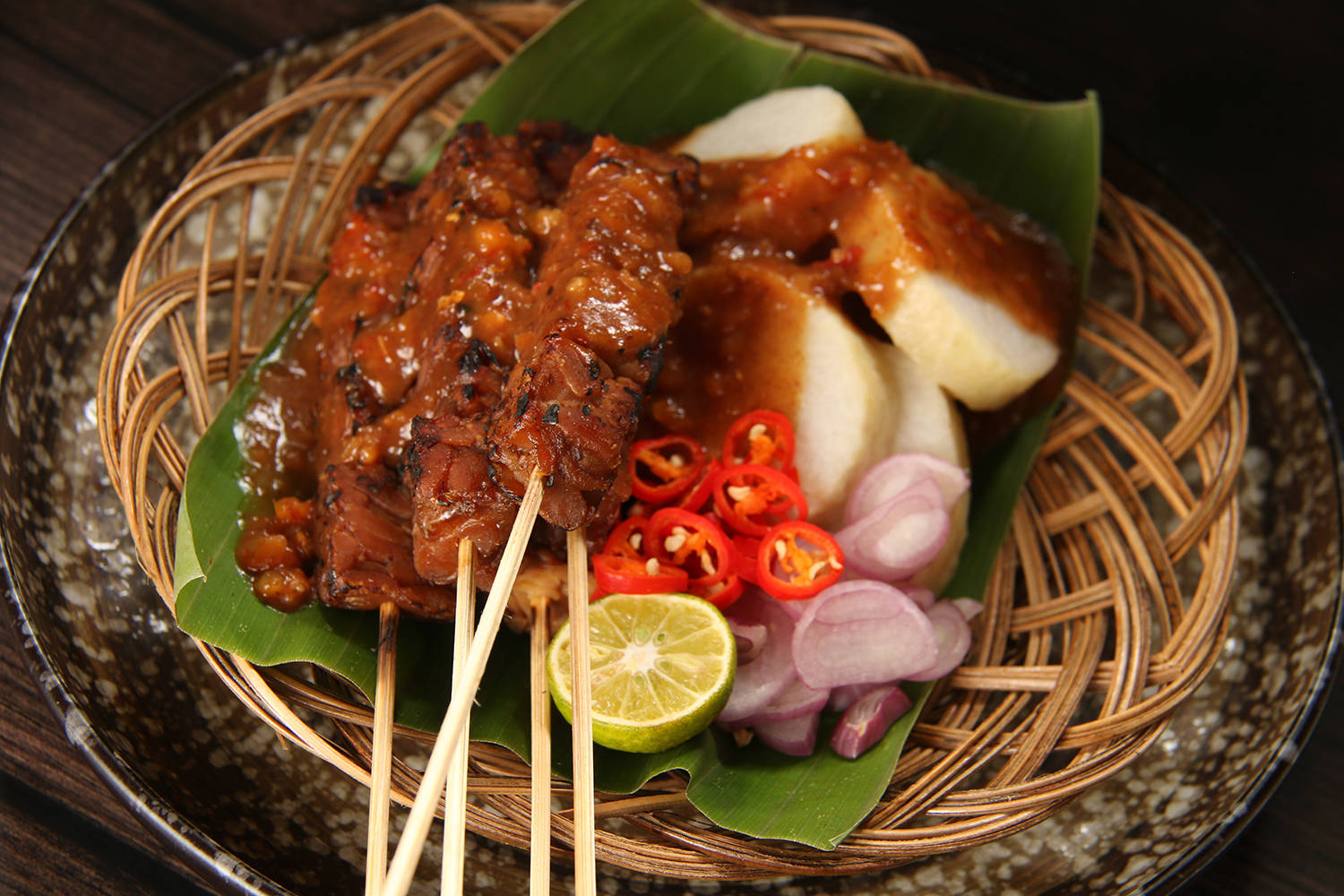 Delicious Food 桌布 壁紙 — 燒烤沙爹串配花生醬和新鮮辣椒洋蔥，放在香蕉葉上，置於編織籃中。