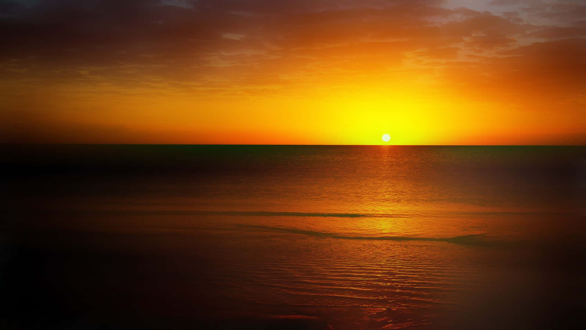 Horizon 桌布 壁紙 — 燦爛的夕陽在橙色和深紫色的漸變天空下，將金色的光芒灑在平靜的海面上。