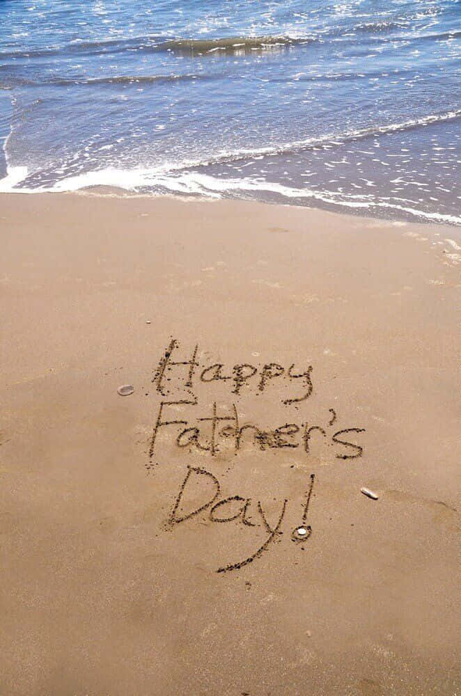 Fathers Day 桌布 壁紙 — 父親節快樂訊息寫在海岸線的濕沙上，溫柔的海浪翻滾而來。