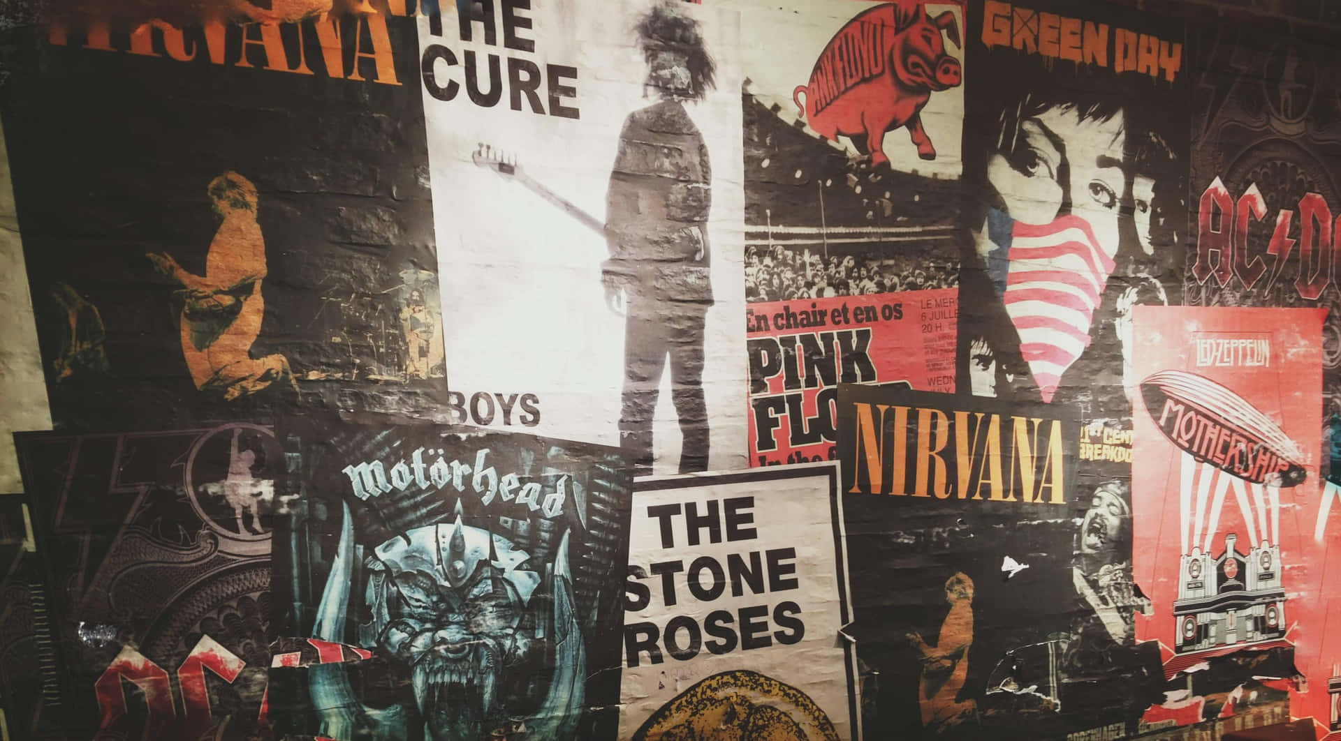 牆上貼滿經典搖滾樂團海報，如Nirvana和The Cure。 — Valorant Logo 壁紙