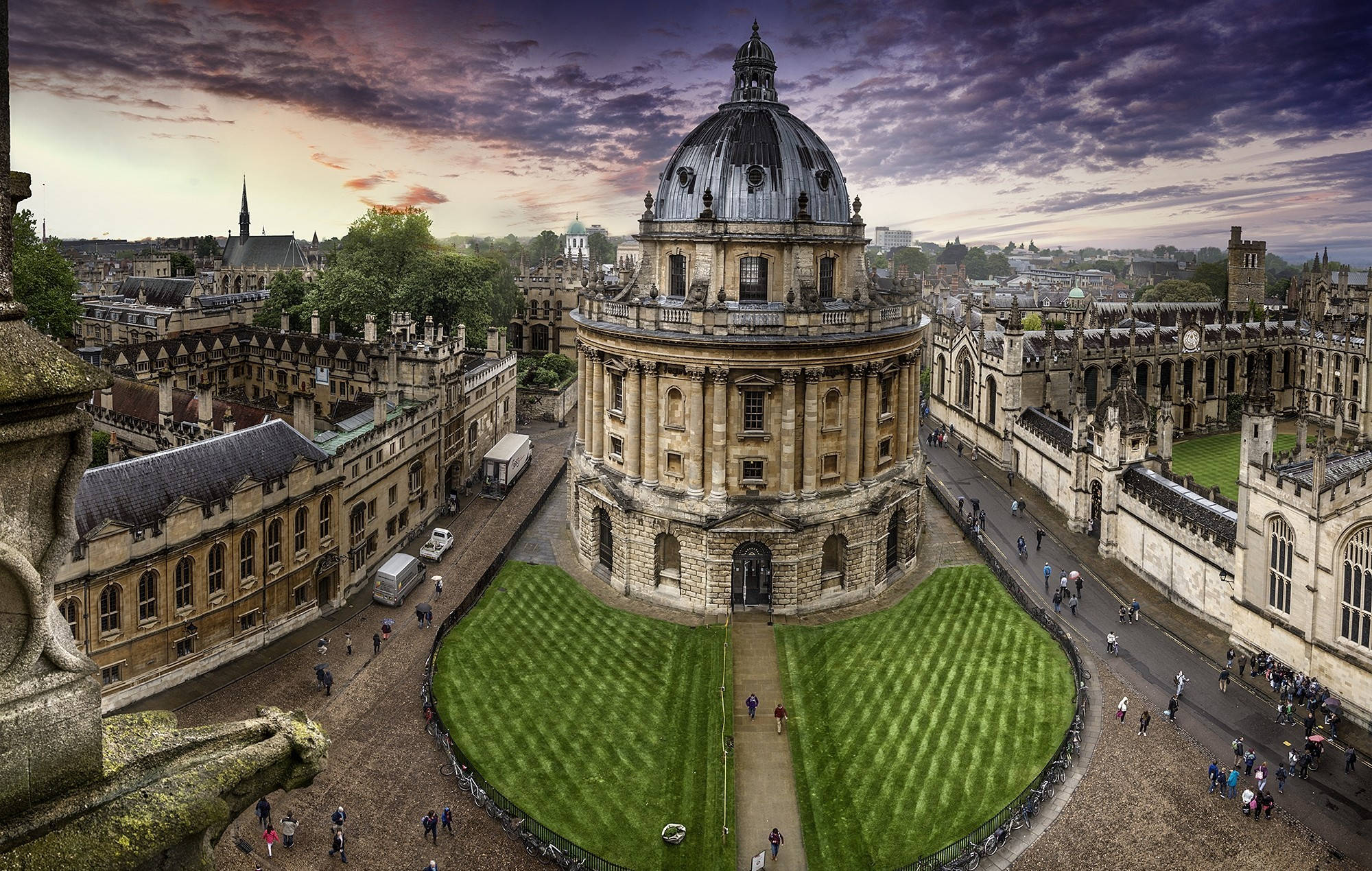 England 桌布 壁紙 — 牛津拉德克利夫相機的日落航拍圖，帶有戲劇性的紫色雲彩和修剪整齊的綠色草坪。