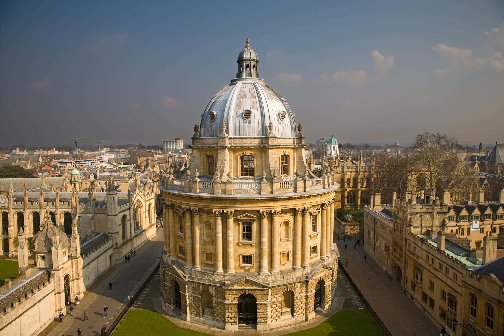 England 桌布 壁紙 — 牛津拉德克利夫相機的空中景觀，其標誌性圓頂圖書館在晴朗藍天下矗立於歷史石建築之中。