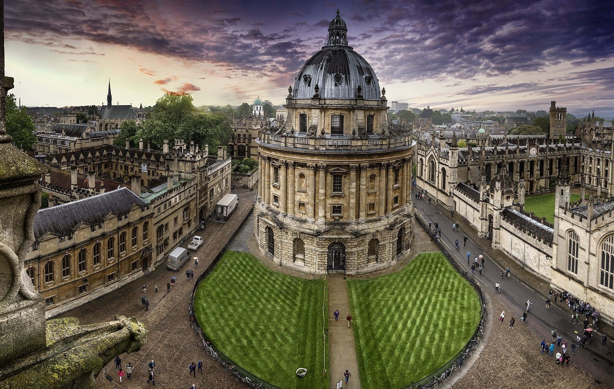 England 桌布 壁紙 — 牛津拉德克利夫相機的空中景觀，日落時分，戲劇性的紫色雲朵和修剪整齊的綠色草坪。