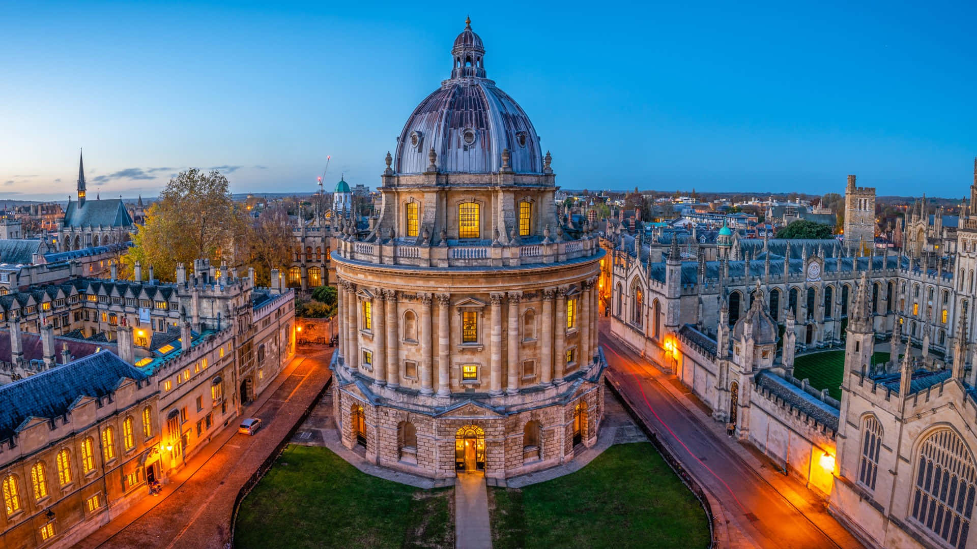 England 桌布 壁紙 — 牛津拉德克利夫相機的黃昏鳥瞰圖，溫暖的燈光在深藍色的天空中閃耀。