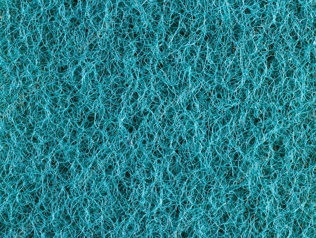 Rough Texture 桌布 壁紙 — 特寫：一塊密集的藍綠色擦洗海綿，帶有纏結的纖維，背景是深色。