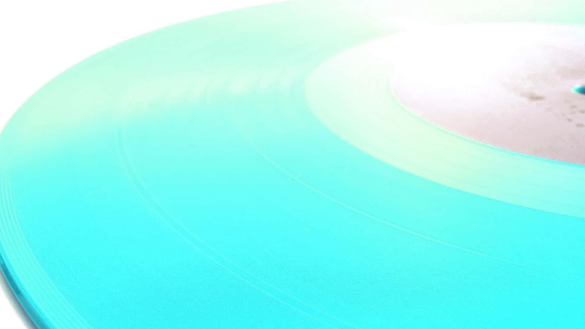 1920x1080 Frisbee 桌布 壁紙 — 特寫：半透明青綠色黑膠唱片，帶有柔和漸變色調和細微的同心圓紋，背景為亮白色。
