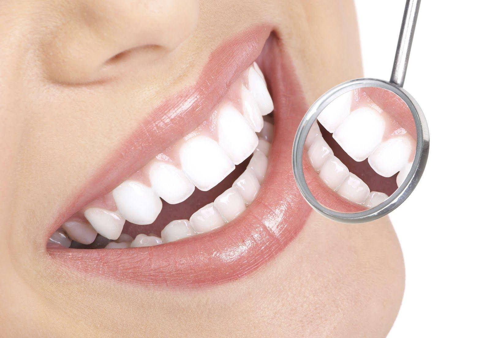 Dentistry 桌布 壁紙 — 特寫：在潔白背景下，用牙科鏡檢查一個人亮白的牙齒。
