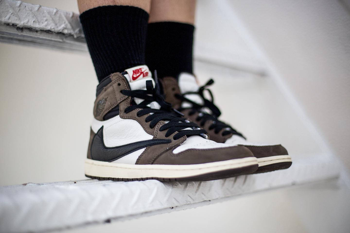 崔維斯·史考特 桌布 壁紙 — 特寫：棕色、黑色和白色的 Nike Air Jordan 運動鞋，放在帶紋理的白色樓梯級上，搭配黑色襪子。