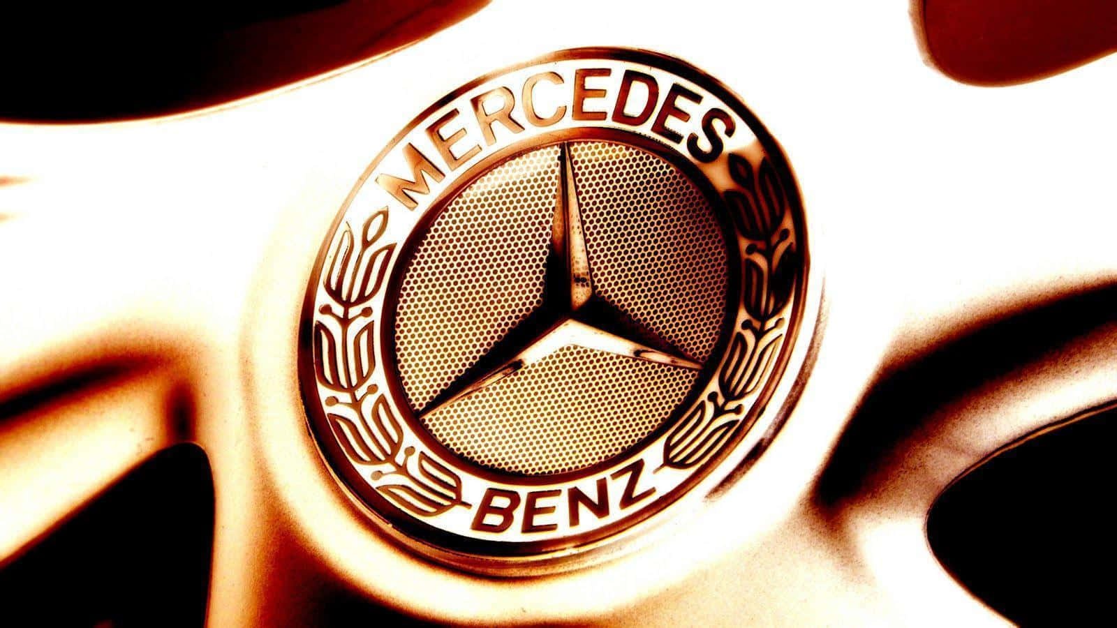 Mercedes Benz Logo 桌布 壁紙 — 特寫：汽車輪圈上的 Mercedes-Benz 徽章，帶有溫暖的金色燈光和淺景深。