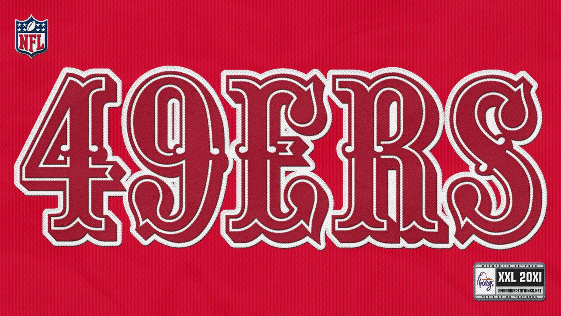 49ers 桌布 壁紙 — 特寫：粗體白色輪廓49ERS文字在紋理紅色NFL足球球衣布料上，附有尺寸標籤。