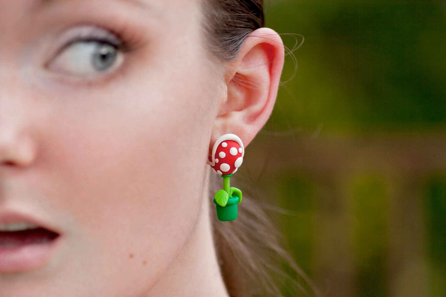 Earrings 桌布 壁紙 — 特寫一位女士戴著紅白圓點蘑菇耳環的驚訝面孔。