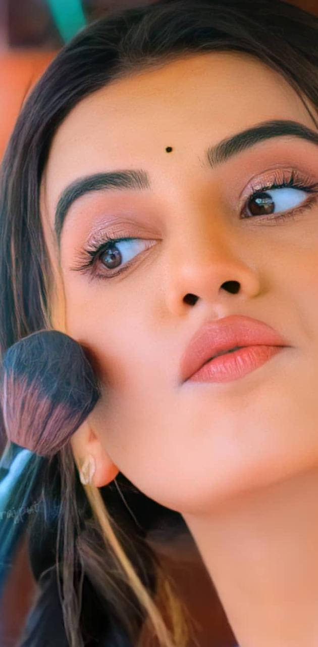 Makeup 桌布 壁紙 — 特寫一位深色頭髮、額頭有紅點的女性，用蓬鬆刷子在臉頰上塗抹腮紅。
