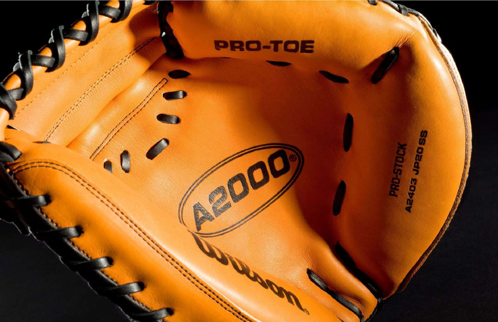 Baseball Gloves 桌布 壁紙 — 特寫一個亮橙色棒球捕手手套，帶有黑色綁帶和 'A2000' 標誌，背景為深色。