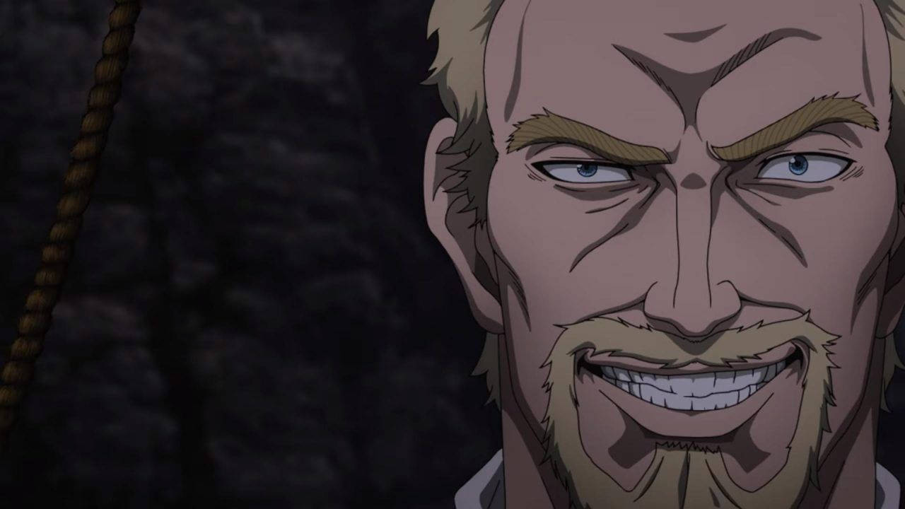 Vinland 桌布 壁紙 — 特寫一個動漫男人，金髮鬍鬚，在黑暗岩石背景下兇猛咧嘴笑。