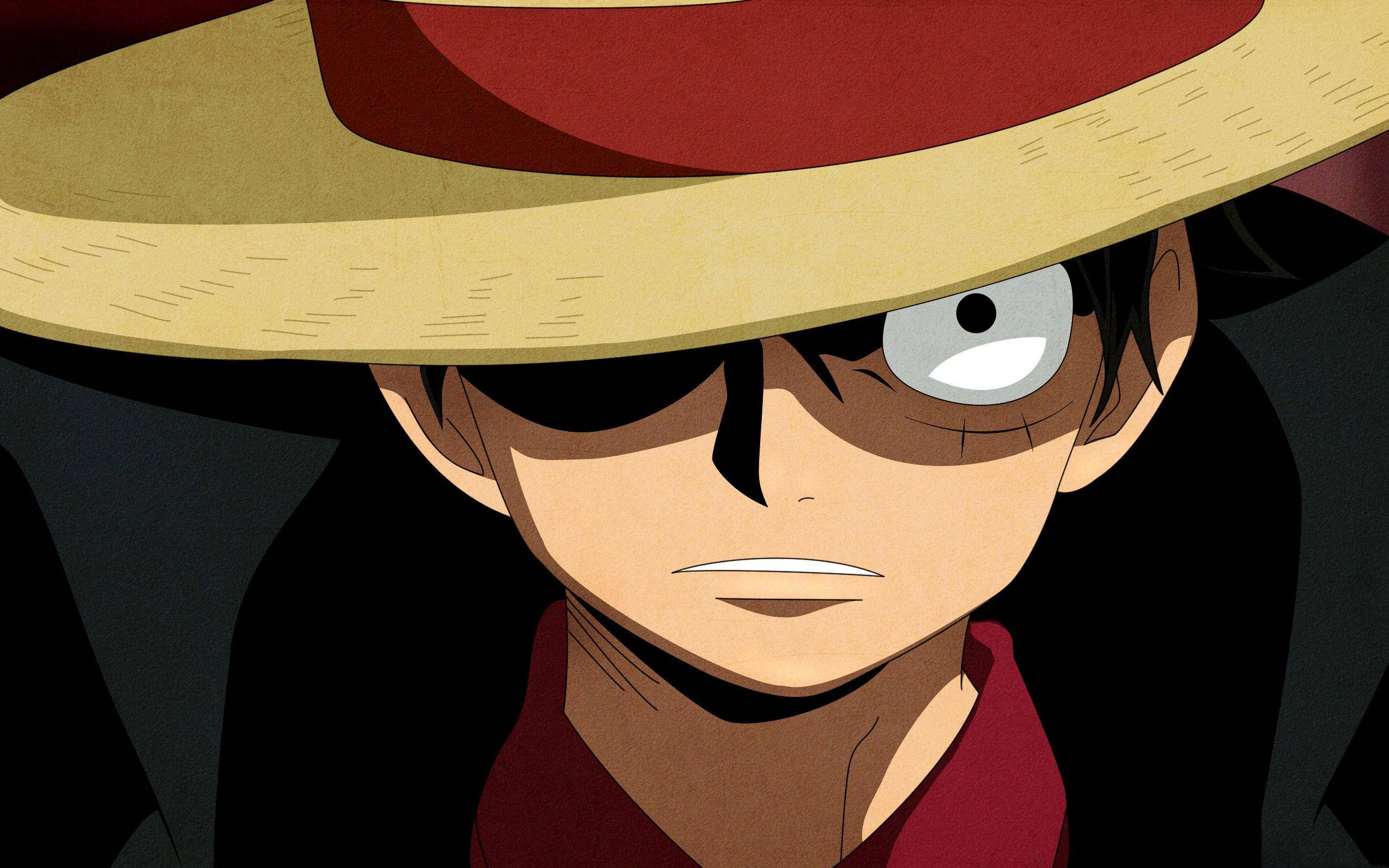 luffy 4K 桌布 壁紙 — 特寫一個堅定的動畫男孩，戴著有紅色帶子的草帽和紅色襯衫，背景為深色。