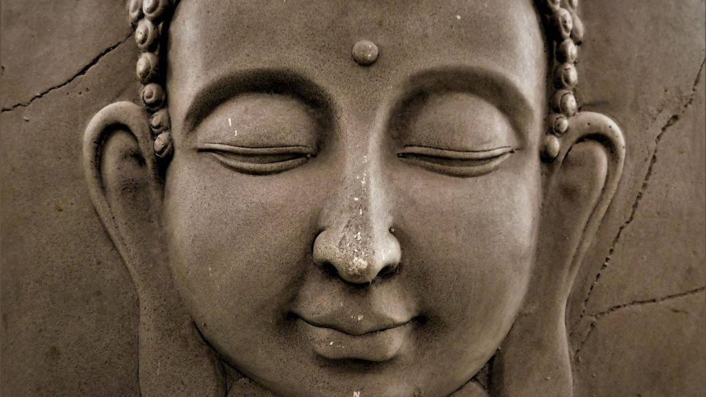 Gautam Buddha 桌布 壁紙 — 特寫一個寧靜的石佛頭，閉著眼睛，有肉髻，背景是裂縫牆壁。