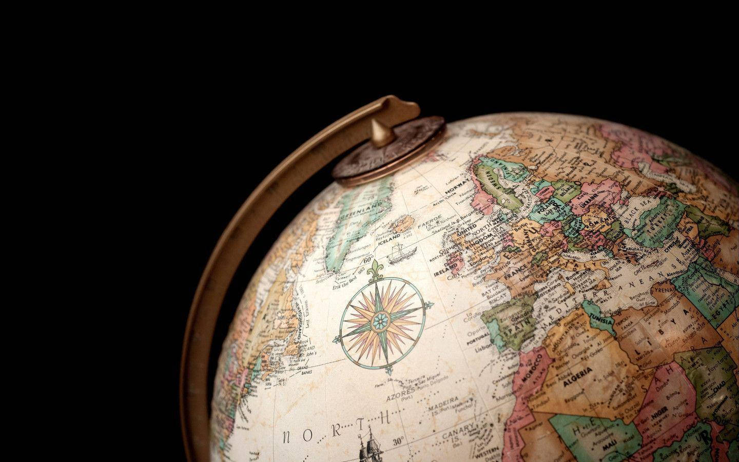 World Globe 桌布 壁紙 — 特寫一個復古地球儀，顯示歐洲和非洲，帶有黃銅子午線，背景為黑色。