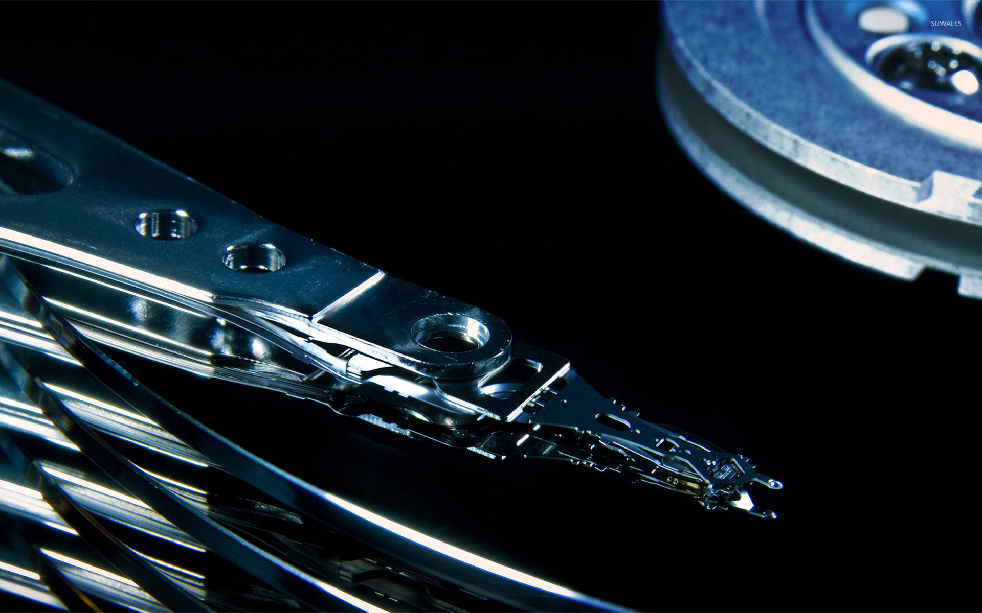Hard Drive 桌布 壁紙 — 特寫一個拆解的硬碟，帶有閃亮的金屬組件，背景為黑色。
