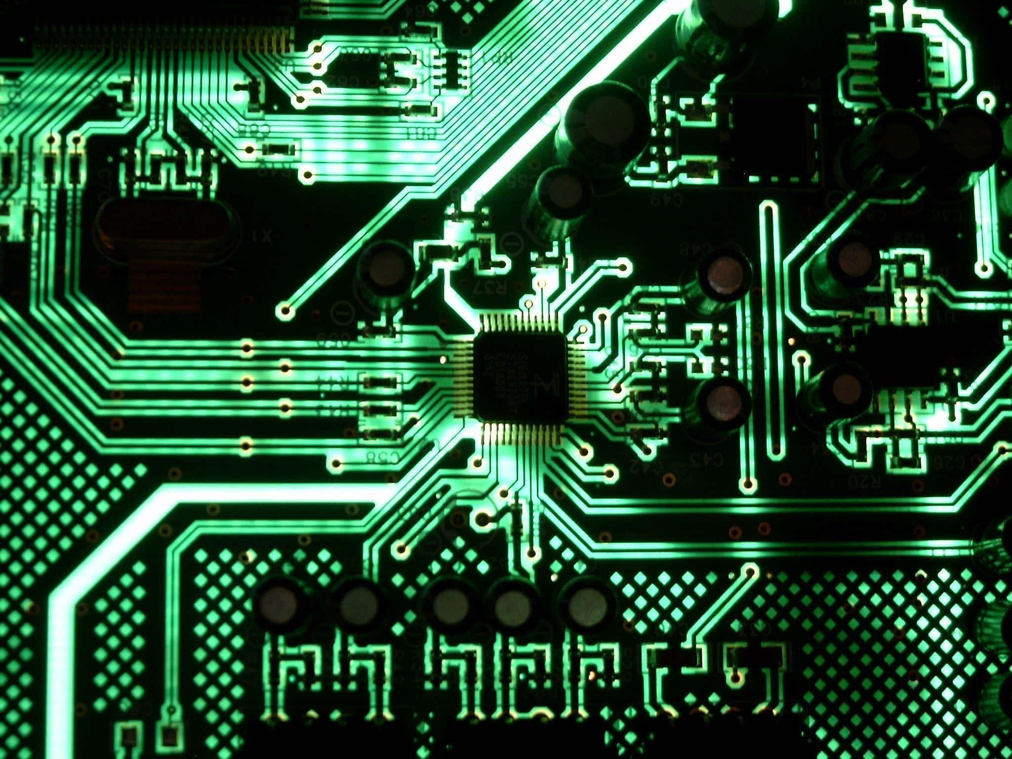 Electronics 桌布 壁紙 — 特寫一個發光的綠色電路板，帶有複雜的線路和一個中央晶片，在黑暗背景下被照亮。