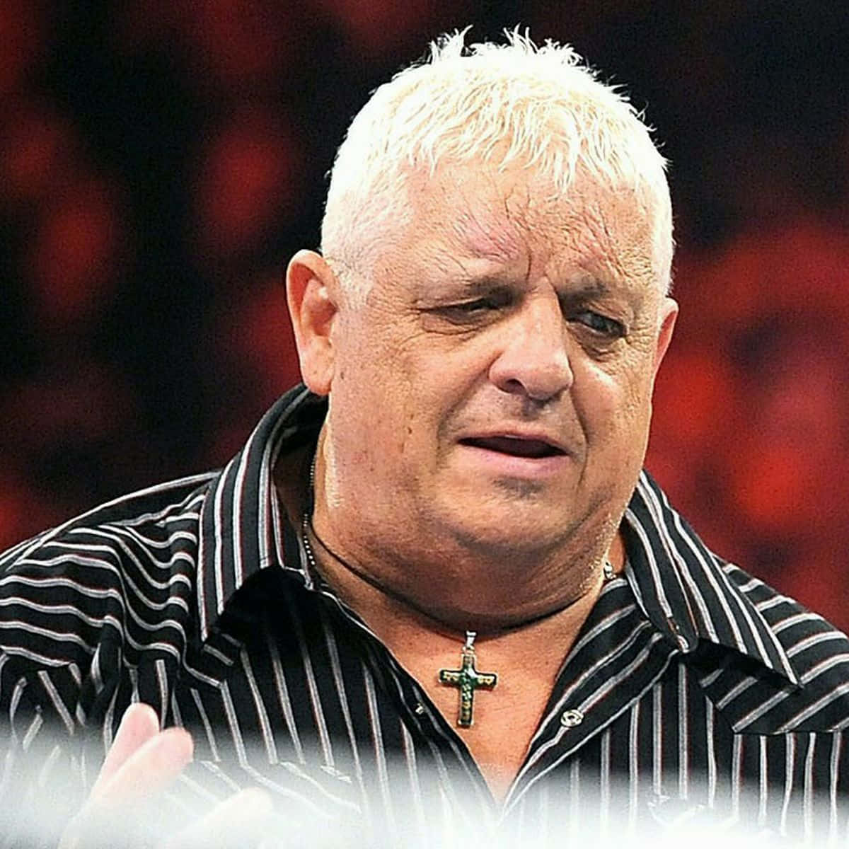 Dusty Rhodes 桌布 壁紙 — 特寫一個白髮男人穿著條紋襯衫和十字架項鍊，背景是模糊的紅色。