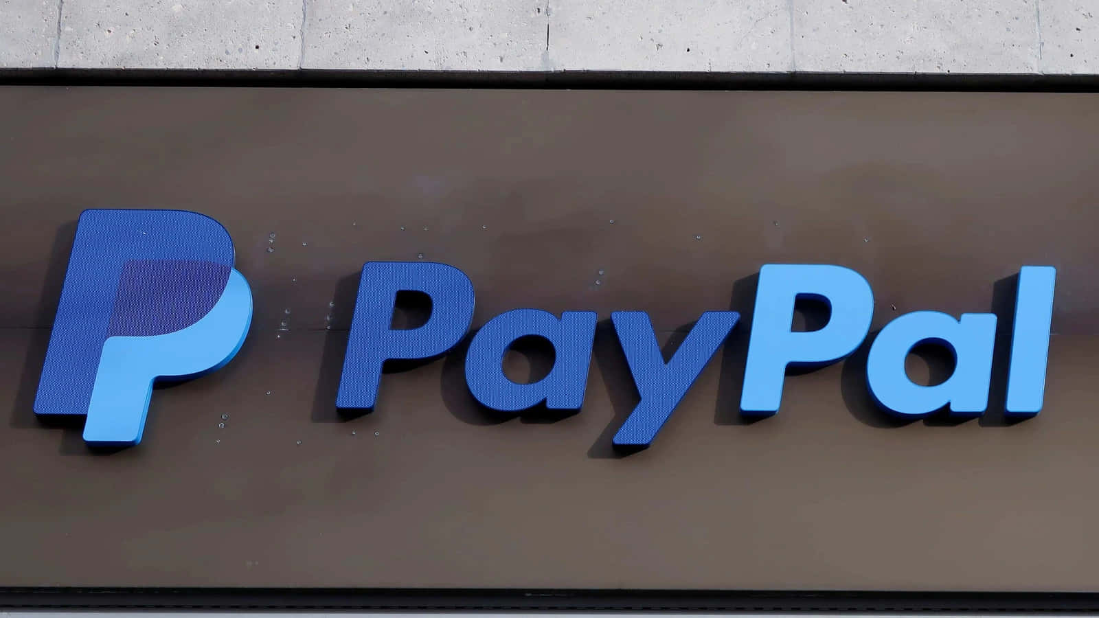 PayPal 桌布 壁紙 — 特寫一個藍色PayPal標誌，帶有3D字體，安裝在混凝土牆上的棕色招牌上。